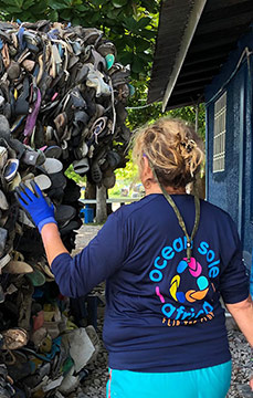 Ocean Sole employee collecting used flip flops to reuse it