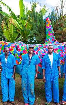Ocean Sole employees presenting a colorful whale made of used flip flops